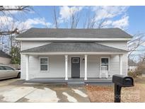 Charming two-story home features a covered front porch, gray siding and a black mailbox at 92 Saint Charles Ne Ave, Concord, NC 28025