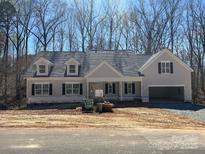 Charming one-story home featuring a side entry garage, dormer windows and a welcoming covered porch at Lot 72.73 Sally Clark Dr, Denver, NC 28037