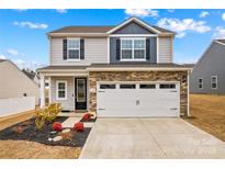 Two-story house with gray siding, stone accents, and a two-car garage at 140 Colonial Reserve Ave, Troutman, NC 28166