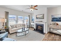 Bright living room features a fireplace, large windows, and comfortable seating at 14517 Winged Teal Rd, Charlotte, NC 28278