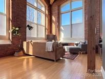 Spacious living room with exposed brick and large windows at 201 S Hoskins Rd # 136, Charlotte, NC 28208