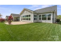 Spacious backyard with a patio and large windows offering views of the manicured lawn at 253 Stone Mountain Way, Denver, NC 28037