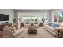 Staged living room featuring neutral furniture, hardwood floors, and lots of natural light at 253 Stone Mountain Way, Denver, NC 28037