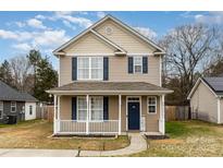 Tan two-story house with white porch and blue door, landscaped yard at 3249 Ian Patrick Ave, Kannapolis, NC 28083