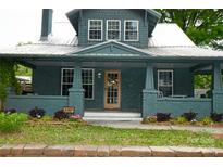 Charming teal painted brick home with a metal roof, inviting porch, and manicured landscaping for curb appeal at 3317 Ritch Ave, Charlotte, NC 28206