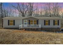 Ranch style manufactured home with front porch and wooded lot at 616 Lhasa Apso Ln, Iron Station, NC 28080