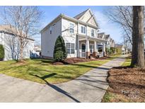 Charming two-story home boasts a welcoming front porch and a well-manicured lawn on a sunny day at 9415 Rosalyn Glen Rd, Cornelius, NC 28031