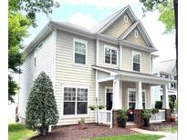Charming two-story home featuring a welcoming front porch, well-manicured lawn, and classic architectural details at 9415 Rosalyn Glen Rd, Cornelius, NC 28031