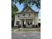 Charming two-story home featuring a cozy front porch and beautifully landscaped front yard, with blue sky in the background at 9415 Rosalyn Glen Rd, Cornelius, NC 28031