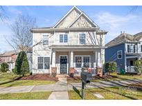 Charming two-story home with a manicured lawn, inviting porch, and a classic architectural design at 9415 Rosalyn Glen Rd, Cornelius, NC 28031