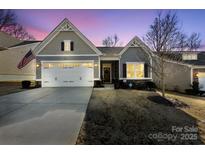 Gray craftsman style home with a two-car garage and American flag at 10225 Black Locust Ln, Charlotte, NC 28215