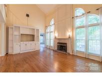 Bright living room featuring a fireplace, hardwood floors, and built-in shelving at 117 Biscayne Ct, Mooresville, NC 28117