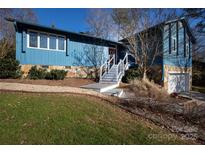 Ranch style home with blue siding, stone accents, and a white staircase at 1432 Jules Ct, Charlotte, NC 28226