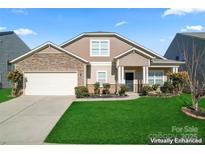 Charming two-story home featuring stone accents, a manicured lawn, and a two-car garage at 1527 Sunflower Field Pl, Matthews, NC 28104