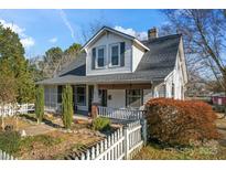 Charming house with white siding, gray roof, and a picket fence at 410 7Th St, Spencer, NC 28159