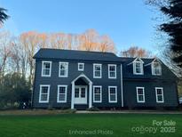 Charming two-story home boasts a classic design with white-trimmed windows and a well-manicured lawn at 5229 Mt Holly Huntersville Rd, Charlotte, NC 28216