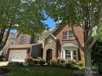 Charming brick home with manicured lawn and stone entryway framed by flowering bushes and mature trees at 626 Lorain Nw Ave, Concord, NC 28027