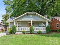 Charming craftsman style home with a gray exterior, front porch, and well-manicured lawn at 1317 Downs Ave, Charlotte, NC 28205