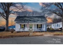 Charming white house with a porch, well-maintained lawn, and mature trees at 298 Misenheimer Nw Dr, Concord, NC 28025