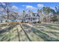 Ranch home with blue siding, white trim, and a red door at 3416 Red Fox Trl, Matthews, NC 28104