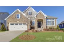 Charming home featuring stone accents, a manicured lawn, and a two-car garage, bathed in sunlight at 45528 Misty Bluff Dr, Charlotte, NC 28278