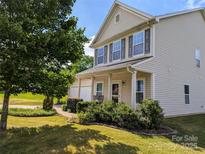 Two-story house with beige siding, brown shutters, and a rocking chair on the porch at 703 Lexington Dr, Albemarle, NC 28001