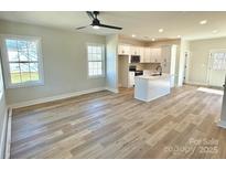 Open concept kitchen with island, white cabinets, and stainless steel appliances at 1026 N Oakwood St, Gastonia, NC 28052