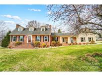 Charming brick home with a well-manicured lawn and inviting front porch and dormer windows at 109 Chanticleer Ct, Charlotte, NC 28214