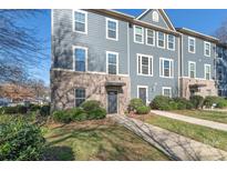 Three-story townhome with gray siding, brick accents, and a walkway at 1304 Queen Lyon Ct, Charlotte, NC 28205