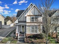 Two-story house with light brown siding, brick base, and a front porch at 13146 Heath Grove Dr, Huntersville, NC 28078