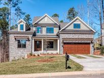 Charming home with a stone facade, inviting curb appeal, and a two car garage at 18140 Kalabash Rd, Charlotte, NC 28278