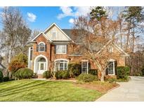 Brick two-story house with a landscaped lawn and large trees at 3504 Mountain Cove Dr, Charlotte, NC 28216