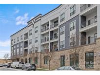Modern apartment building with brick and gray siding, balconies, and ample parking at 3630 N Davidson St # 2210, Charlotte, NC 28205