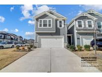 Gray two-story townhome with a two-car garage and landscaping at 4512 Iron Oak Ln, Charlotte, NC 28269