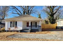 Charming white house with gray accents, a covered porch, and a fenced yard at 832 Richard Ave, Kannapolis, NC 28081