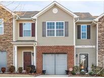 Two-story townhome with brick and stone accents, two-car garage, and landscaping at 9408 Hamel St, Charlotte, NC 28215