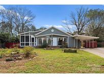 Gray house with screened porch, landscaping, and carport at 106 Wexford Ct, Charlotte, NC 28210