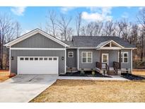 Charming single-Gathering home features a gray exterior, attached garage, and inviting front porch at 122 Stockbridge Ln, Statesville, NC 28625