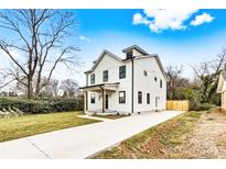 Charming two-story home with white siding, black trim windows, covered porch, and a concrete driveway at 1408 Camp Greene St, Charlotte, NC 28208