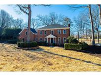 Stately two-story brick home featuring mature landscaping, a manicured lawn, and classic architectural details at 3467 Rock Bridge Dr, Conover, NC 28613