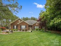Charming brick home with a well-maintained lawn and mature trees, offering curb appeal and a welcoming atmosphere at 416 Zelkova St, York, SC 29745