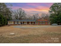Brick ranch home with a large yard and circular driveway at 9330 Bellhaven Blvd, Charlotte, NC 28214