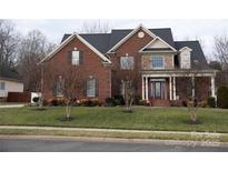 Brick two-story home with a front porch and landscaped yard at 112 Daniel Efird Dr, Mount Holly, NC 28120