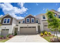 Two story townhome with taupe garage door and landscaping at 14926 Tamarack Dr, Charlotte, NC 28278