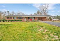 Charming brick ranch-style home with a covered front porch and well-manicured landscaping at 549 Dairy Rd, Troy, NC 27371