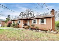 Brick ranch house with landscaped lawn and walkway at 6520 Weldon Nw Cir, Concord, NC 28027