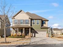 Two-story house with green and beige siding, a two-car garage, and a basketball goal at 1000 Lily Pond Cir, Waxhaw, NC 28173