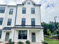 Charming three-story townhouse with a modern farmhouse-style exterior and a gray front door at 15306 Ballancroft Pkwy # 21, Charlotte, NC 28277