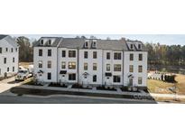 Three story townhouses with white siding and black roofing at 15306 Ballancroft Pkwy # 21, Charlotte, NC 28277