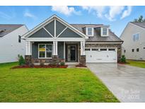 Charming new home with craftsman-style details, stone accents, and a two-car garage at 4005 Grace Pointe Dr # 100, Wesley Chapel, NC 28079